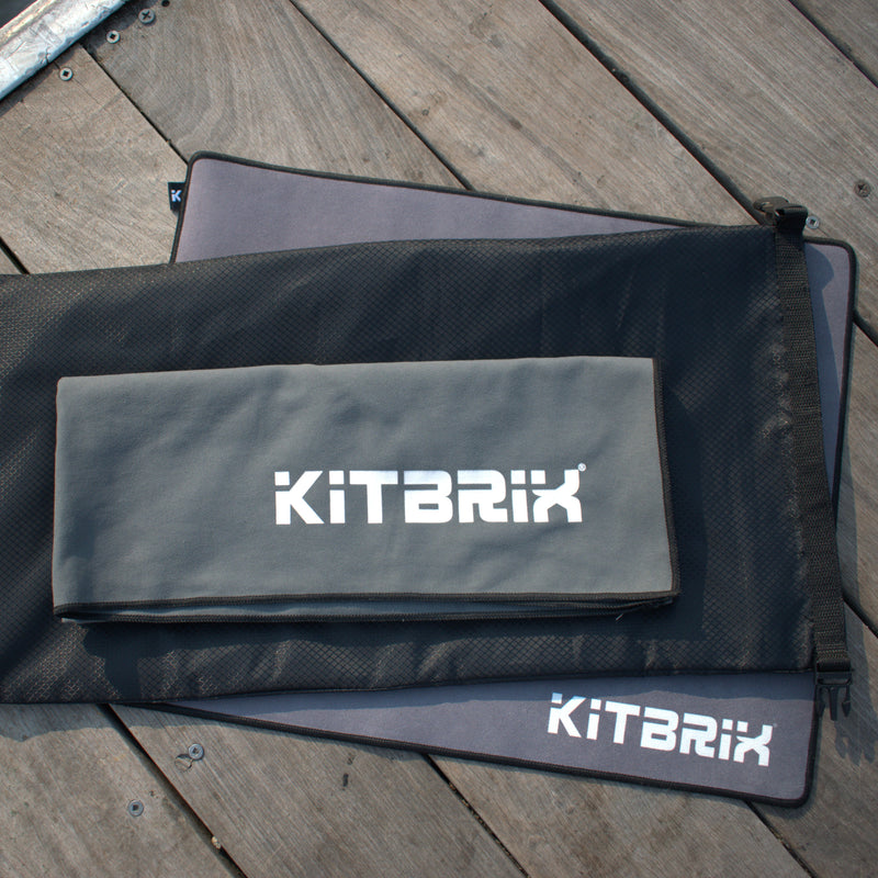 KitBrix change mat, dobi dry bag, and microfiber towel accesories on wooden dock